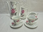 Jogo de servir café com 5 peças em porcelana Schmidt floral. Medindo o bule 18,5cm de altura. Bule e açucareiro sem tampa.
