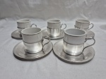 Jogo de 5 xícaras de café em porcelana com suporte e pires em prata 90 Cristofoli. Medindo 5cm x 5,5cm de altura.