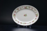 JOHNSON BROS - Pequena travessa em faiança inglesa, na tonalidade off white, ornamentadas com rosas e folhagens em rica policromia. Borda acordoada decorada com friso ouro folha. Medidas: 27 x 21 cm.England Britain Castles (Staffordshire, Reino Unido, 1883  China, 2015), mais conhecida como Johnson Brothers, foi uma fabricante e exportadora de cerâmicas e porcelanas britânica.