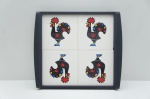 Bandeja portuguesa decorativa, com superfície esmaltada apresentando composição de quatro imagens do tradicional Galo de Barcelos  ícone do folclore de Portugal associado à sorte e prosperidade. A estampa traz cores vivas e detalhamento estilizado, criando um visual marcante e contemporâneo. Peça de formato retangular, com bordas elevadas para melhor funcionalidade, ideal tanto para uso prático quanto como elemento decorativo de inspiração cultural portuguesa Medidas: 37 x 32 cm.
