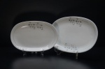 RENNER- Duas travessas em porcelana branca, moldada na pasta. Ornados com dentes de leão em policromia, borda filetada a ouro folha. Tamanhos diferentes. Marca da Manufatura no fundo. Medidas: 28 x 19 cm / 33 x 22 cm.