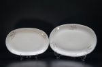 RENNER- Duas travessas em porcelana branca, moldada na pasta. Ornados com três galhos com motivos  em policromia, borda filetada a ouro folha. Tamanhos diferentes. Marca da Manufatura no fundo. Medidas: 28 x 19 cm / 33 x 22 cm.