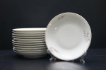 RENNER- Doze pratos fundos, porcelana branca moldada na pasta. Ornados com galhos e motivos em rica policromia, borda filetada a ouro folha. Marca da Manufatura no fundo. Diâm. 22 cm.