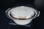 Myott & Son Ltd. (1885-1991) - Graciosa terrina em porcelana inglesa, moldada na pasta, fundo na tonalidade marfim. Déc.90, Borda Adornada com faixas na tonalidade azul cobalto, frisos e folhagens à ouro folha. Pega anelar moldada. Marcada no fundo. Alt. 13x Diâm. 25 cm.