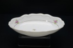 SCHMIDT- Pequena travessa em porcelana branca. Déc. 60, borda gomada. Adornada com rosas e folhagens esparsas. Frisos à ouro folha. Base e alças moldadas em volutas. Marca da Manufatura no fundo. (Lascados na borda). Medidas: 29 x 19 cm.