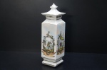 Gracioso potiche retangular, porcelana branca, em formato de gazebo. Ornamentado com cenas orientais em rica policromia. Borda, tampa e corpo filetados a ouro folha. Alt. 30 cm. (Desgastes de tempo).