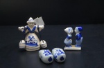 Três peças decorativas em porcelana holandesa, adornadas na tonalidade azul cobalto sobre fundo branco. Populares na cidade de Delft. Sendo: Camponesa carregando baldes, pequena figura de casal e tamancos holandeses. Maior alt. 7,5 cm.