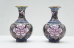 Jingfa- Par de vasos em metal cloisonné, fundo preto, dito balaústre. Adornado com frisos e nunves em linha fina dourada. Bojo esmaltado com flor de lótus e motivos em rica policromia. Alt. 13 cm. 