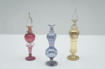 Três perfumeiros em vidro veneziano colorido (um sem tampa). Maior alt. 15 cm; Menor alt. 12 cm.
