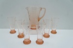 Jarra refresqueira e seis copos para longdrink em vidro, na tonalidade salmão. Lapidado com motivos geométricos. Alt. 22 (jarra) e 17 cm. (copos).