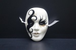 Graciosa Mascara veneziana, decorativa, confeccionada em porcelana branca. Esmaltada com faixas e adornos na tonalidade preta aplicada à ouro folha. Populares na década de 80. Medidas: 13 x 9 cm. (apresenta 1 bicado na parte interna).