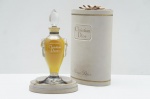 Magnífico e raro Perfume Miss Dior na versão Extrait de Parfum (ou Perfum Puro), um ícone da alta perfumaria vintage. O frasco tem um Design de Ânfora atribuído a Baccarat, símbolo de luxo e dos primeiros lançaments da Maison Christian Dior em 1947. O frasco confeccionado em cristal possui formato estilizado, com nome "Christian Dior" em relevo. É coroado com imponente tampa facetada em formato de ponta de diamante, vedada originalmente com cortiça e barbante  (baudruche). Possui estojo original com acabamento em veludo bege, com frisos dourador e fita na parte superior. Frasco fechado com 60 ml. Marcado 2 FL. Oz. Frasco alt. 17 cm / Estojo alt. 20 cm.