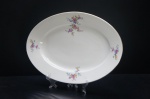 MZ Czechoslovakia (1922-1945) - Graciosa Travessa confeccionados em porcelana tcheca, fundo branco. Adornada com ramos de flores e folhagens em rica policromia. Borda e motivos filetados à ouro folha. Marca da Manufatura no fundo. Dimensões: 40 x 27 cm.
