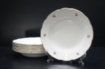 Elegante conjunto composto por sete pratos fundos, cada um com diâmetro aproximado de 23 cm, marcados com a inscrição S. Richards  Made in Italy  871 no verso. Fabricados com refinamento em porcelana italiana de tonalidade branca, as peças trazem delicado motivo floral policromado ao longo da borda e acabamento em filete dourado, conferindo leveza, sofisticação e apelo decorativo.Produção e marcação que remetem à tradição italiana de louças de mesa no século XX  a marca Società Ceramica Richard (também conhecida como Richard) foi documentada já no final do século XIX em Milão, o que sugere que peças marcadas Made in Italy com numeração como 871 provavelmente datem de meados do século XX, em linha com produção industrial de louças de luxo italianas.