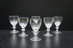 Seis tacinhas para licor em demi-cristal, translúcido, lapidado no padrão dedão e caneluras. Haste com anel gomado. Alt. 7 cm.