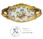 KLEIBER - ALEMANHA - Raríssima e linda travessa de coleção, executada finamente em porcelana de excelente qualidade e renomada manufatura, adornada por belo motivo floral ao centro e riquíssima cobertura á ouro 22. Perfeito estado de conservação. Mede 3,5 cm de altura x 21 cm de comprimento x 11 cm de largura.