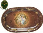 Hutschenreuther, BAVARIA - ALEMANHA - Rara e linda travessa de coleção, feita em antiga porcelana de excelente qualidade e manufatura. Adornada por rico trabalho com ouro e expressivas figuras ao centro. Bom estado de conservação, mede 275 x 17,5 cm. Alemanha, início/ meados do Século XX.