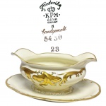 ALEMANHA - ´´FRIEDERIKE´´ - Belíssima e rara molheira retrô de coleção, executada finamente em porcelana de excelente qualidade e manufatura, adornada por riquíssimo trabalho em relevo com cobertura á ouro. Perfeito estado de conservação. Mede 8 cm de altura x 23 cm de comprimento x 15 cm de largura. Alemanha, meados do Século XX.