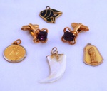 Cinco (05) peças, sendo quatro pingentes diversos, par de abotoaduras douradas com pedra ametista. Med. pingente maior 3 cm.