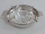 Porta caviar em metal espessurado à prata com suporte interno, sustentando recipiente em vidro. Med. 8 x 25 cm entre alças.