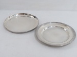 Duas (02) travessas redondas em metal espessurado a prata,fundo liso. Uma marcada WOFF. Med. 29,5 cm diâmetro.