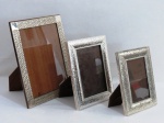 Três (03) porta retratos retangulares em madeira com moldura em metal prateado com vidro em três tamanhos e com suporte.. Meds 29 x 23 ,23 x 18 cm, 21 x 15 cm. Prateação com marcas do tempo.