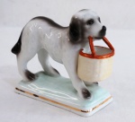 VISTA ALEGRE- Paliteiro de coleção, confeccionada em fina porcelana portuguesa  policromada e filetada a ouro, representando cão com cesto. Marcado e numerado. Med. 10 x 10 cm.