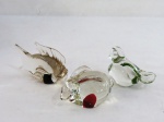 SÃO MARCOS- Conjunto com três (03) peças decorativas em Murano translúcido com bolhas internas coloridas sendo; pomba, coelho e peixe. Meds. maior 10 cm.