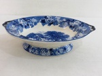 WOODS WARE ENOCK WOODS ENGLISH SCENERY- Fruteira em faiança inglesa, base redonda, bojo alto com alças laterais, decorada ao centro com cenas campestres, bordas e bases com florais na cor azul. Marcada. Med. 7 x 29 cm diâmetro.