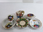 Três (03) xícaras japonesas para café de coleção e seus respectivos pires, sendo, a) Uma pintada a mão com flores e dourações . b) Uma marcada S.G.K Ocupied Japan, c) Uma decorado ao gosto Capodimonte com figuras Mitológicas em relevo ( está com minúsculo bicado na borda).