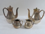 WOLFF- Conjunto para chá e café em metal espessurado a prata, composto: bule para chá, bule para café ( 18 cm alt), cremeira, açucareiro s/tampa. Bule para café com pequena mossa. VENDIDO NO ESTADO.