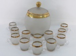 Linda poncheira em vidro fosqueado com largas faixas decorativas em dourado. Tampa com pega esférica. Acompanha 12 canecas no mesmo padrão.Med. 30 x 23 cm diâmetro