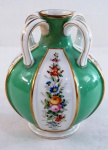 VISTA ALEGRE-  Graciosa jarra em porcelana portuguesa, corpo bojudo em gomos esmaltado com flores em policromia, intercalando frisos em tom verde esmeralda. Obs: Antigo restauro na borda e pequeno bicado. Med. 16,5 cm alt x 13 cm diâmetro.