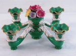 VISTA ALEGRE- Imponente candelabro baixo em porcelana portuguesa, com quatro braços na cor verde esmeralda, decorada com flores em relevo e policromia. Acompanha três bobeches onduladas com frisos dourados. Marca de manufatura do período de "1947 a 1968. Med. 17 cm alt x 37 cm diâmetro.