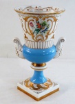 VISTA ALEGRE-  Ânfora em porcelana portuguesa, esmaltagem vitrificada adornada com pintura floral e guirlandas sobre fundo azul com realces em ouro brunido. Base quadrangular. apresenta ao fundo Marca de manufatura do período de "1947 a 1968 . Med. 33 cm alt x 18 cm diâmetro.