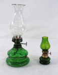 Dois (02) antigos lampiões em vidro verde, manga translúcida com babados. Meds maior 21 cm alt, menor 10 cm alt.