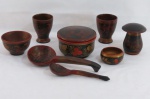 ARTESANATO RUSSO- Oito (08) peças em madeira laqueada de preto com pinturas florais em policromia composto: Pote com tampa ( 10 x 14 cm), dois copos ( 10 cm alt), pote formato cogumelo ( 11 cm alt), duas tigelas, duas colheres ( 25 cm comp a maior). A menor com bicado na borda.