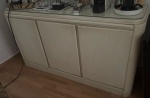 Buffet em madeira patinada no tom marfim, com três portas, vão central com 2 gavetas, interior vazado com uma prateleira cada. Med. 80 x 150 x 46 cm. RETIRADA POR CONTA DO ARREMATANTE NO JARDIM BOTÂNICO COM AGENDAMENTO.