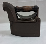 Antigo ferro de passar roupas a carvão dec. 50 em ferro fundido preto com cabo de madeira em bom estado. Med. 20 x 20 x 11 cm.