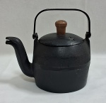 Antiga chaleira dec. 50 em ferro fundido , cabo articulado, pega da tampa em madeira. Med. 17 x 13 cm..