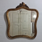 Antigo espelho em cristal bisotado com moldura em madeira patinada em dourado, decorada na parte superior com guirlandas. Apresenta pequenas marcas de oxidação. Med. 76 x 66 cm.