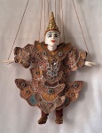 Thar-Gya-Min,  (Birmânia) Marionete de cordas vintage MINTHAR , esculpida em madeira articulada e vestida com indumentária tradicional asiática ricamente ornamentada de miçangas e lantejoulas . A peça apresenta notável trabalho manual .Nat (divindade) Yoke Thé. Toda articulada, cabeça, boca, antebraço, braço, perna e pés. Med. 38 cm alt.