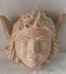 Escultura em pedra sabão representando "Cabeça de Anjo". Peso 1150 kg. Med. 9 x 13 x 14 cm.