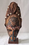 ARTE AFRICANA- Máscara " Kuba" de arte tribal africana NGAADY MWAASH, esculpida e entalhada em madeira e decorada com contas, conchas e búzios em policromia com turbante em tecido. Acompanha pedestal. República de Angola, séc. XX. Med. 38 cm altura.
