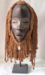 ARTE AFRICANA- Máscara Tribo Dan - Arte Africana ,em madeira esculpida com resquícios de policromia. Costa do Marfim. Século XX.  com detalhes de cordas e búzios. Acompanha suporte e pedestal. Med. 43 cm alt. As máscaras desse povo são utilizadas por homens em eventos religiosos ou em momentos de entretenimento. Para os Dan, o mundo é dividido em dois: o reino dos homens e o "Bon", onde os seres humanos convivem com os animais, e essas máscaras são usadas para que uma pessoa receba mensagens desses espíritos.