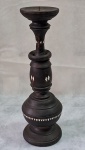 Castiçal em bloco de madeira, decorado com aplicaçoes de madrepérola e argolas. Med. 28 cm alt. Base com veio.