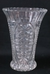Vaso em vidro translúcido prensado, decorado no bojo com estrelas e caneluras, base estrelada. Med. 22 cm lt x 5 cm diâmetro.