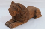 Escultura em bloco de madeira entalhada representando Leão. Med. 17 x 34 x 13 cm.