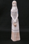 Escultura em porcelana representando  " Figura de uma dama com cesto de flores estilo LLadro. Medindo :26 cm altura.