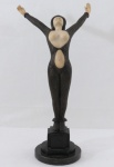 ART DECO- Escultura representando " Dourga" em resina patinada na cor bronze, busto, ventre e mãos na cor marfim. Base em granito preto. Med. 48 cm altura.